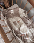 Baby blanket with teddy patterns on a wooden bassinet