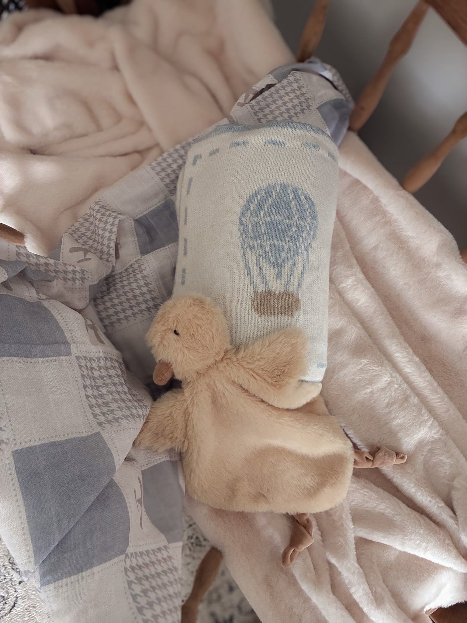 Baby comfort blanket with plush toy on a crib