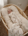 Newborn baby wrapped in a vintage floral blanket wrap