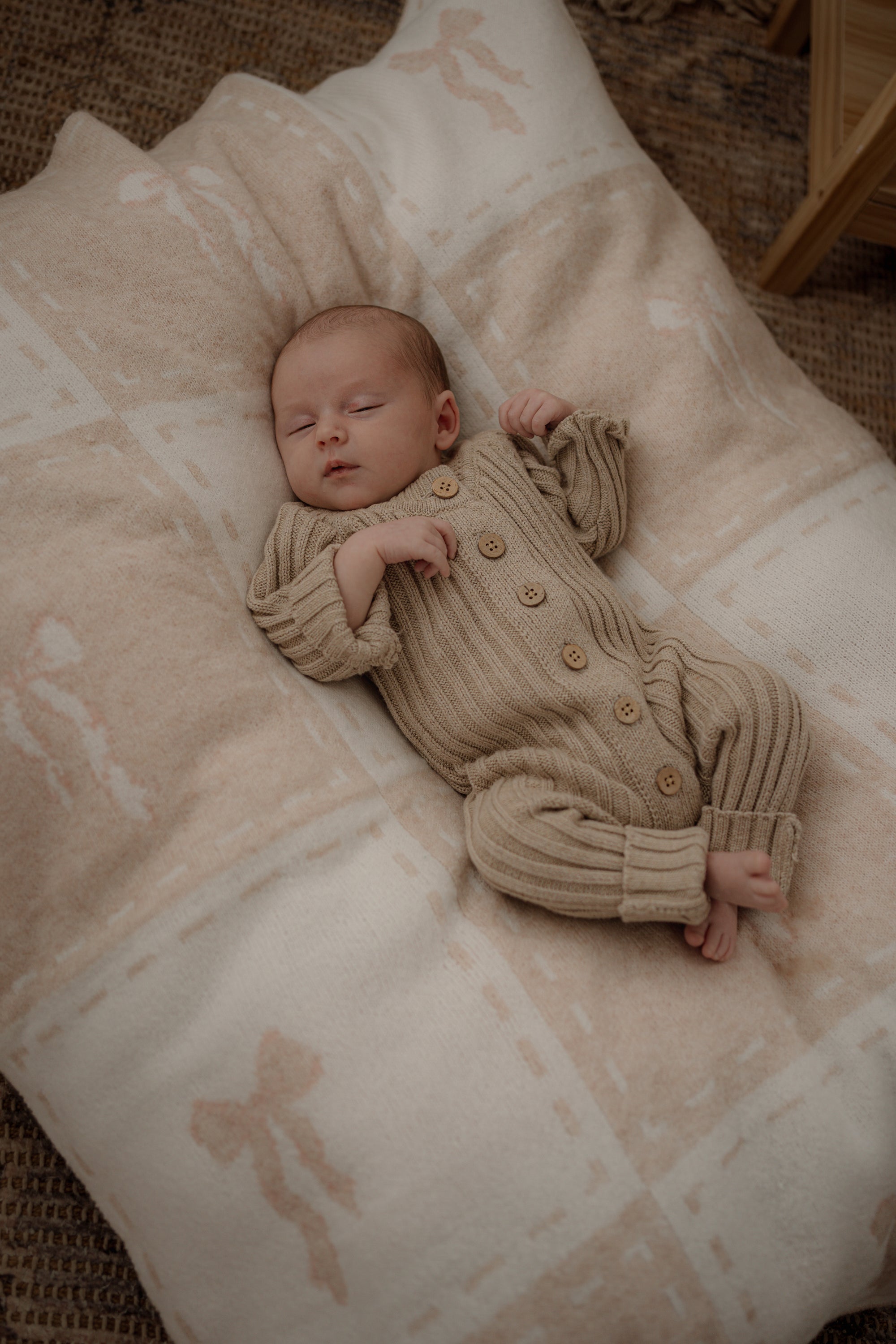 Newborn baby lying on a pink bow blanket