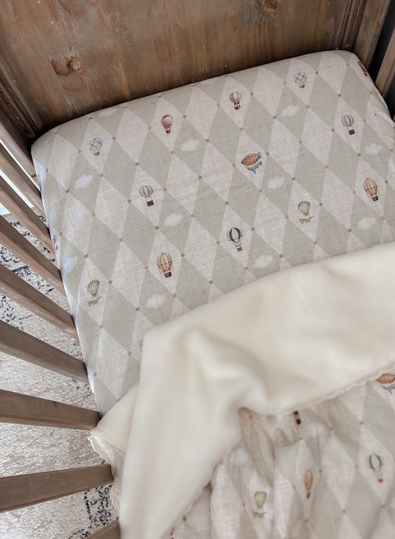 Vintage cot with a Up and Away fitted cot sheet and quilt 